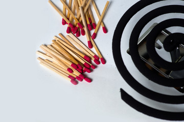 Matches and Burning mosquito coils on white background.