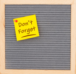 Don't Forget message on sticky note on gray felt letter board