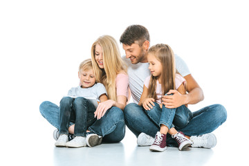 happy kids sitting near cheerful parents on white