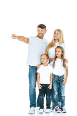 Fototapeta na wymiar happy man pointing with finger near wife, son and daughter on white