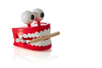 Clockwork jaw toy with sharpened pencil in teeth isolated on white background. Copy space.