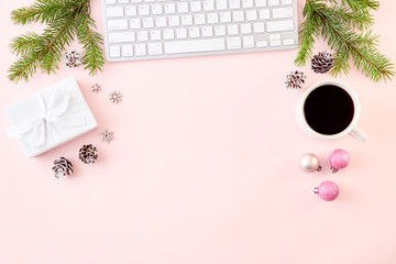 Flat lay christmas home office desk with spruce branches and keyboard, christmas decorations on a colored background