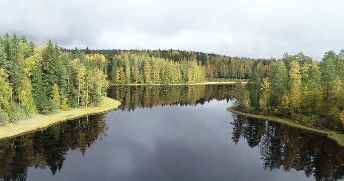 Aerial view of a beautiful lake in the forest with colorful trees during fall season. Taken in Kuru, Finland.