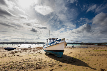 Saint Suliac village, Brittany France. Docked fishing boat by low tide.