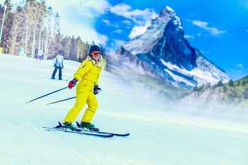 Fototapeta na wymiar Panoramic shot of a female skier resting on top of the mountain observing nature at ski resort on a beautiful sunny winter day copyspace peaceful recreational vacation travel concept