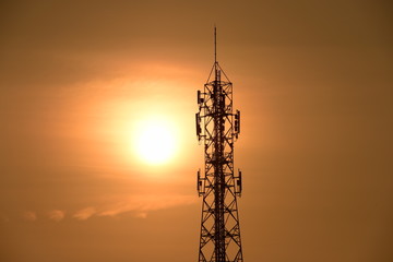 Telecommunication tower with orange sky.Telecommunication towers with TV antennas and satellite dish