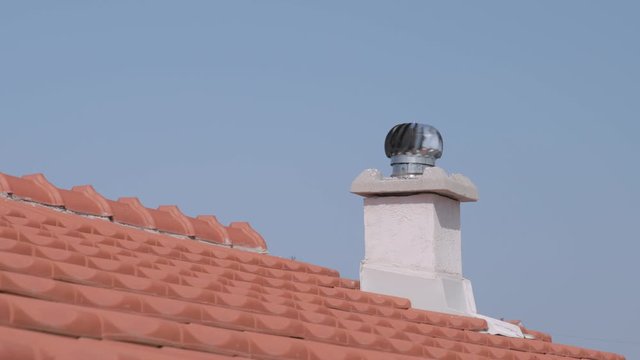 A spinning turbine air vent on a rooftop,rotating and sucking hot air out of a house.
