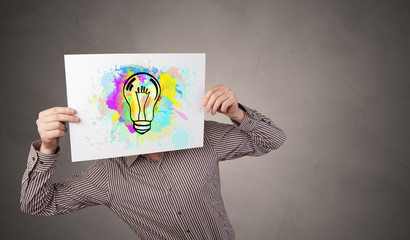 Person holding a paper with a drawn colorful idea concept