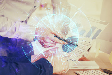 Double exposure of Man writing in notepad with business icons on background.