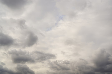 Autumn sky with gray heavy clouds. where no light blue sky looks. Horizontal orientation.