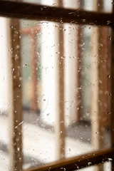 Window with raindrops. Outside the window you can see the windows of the adjacent wall. Blurry background. Vertical orientation