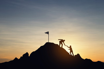 Silhouette of people helping each other hike up a mountain at sunset background. Teamwork, success and goal concept. - obrazy, fototapety, plakaty