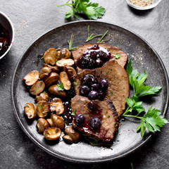 Cooked beef with mushrooms and blueberry sauce
