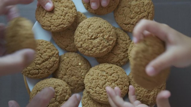Oatmeal cookies. Hands taking oatmeal cookies.