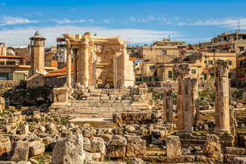 The ruins and only fragment of Venus temple left with modern houses and blue sky in the background,...