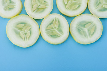 Fototapeta premium Close up fresh slice cucumber on blue