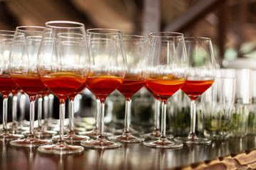 A lot of cocktails at the bar at the wedding party. Glasses with apperol and with a slice of lemon close up