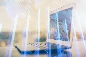 Stock market graph on background with desk and personal computer. Double exposure. Concept of financial analysis.
