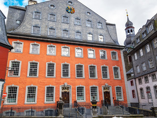 Beautiful streetscape with old buildings in Monschau downtown, Germany, the Rotes Haus or Red House and the Evangelical Church