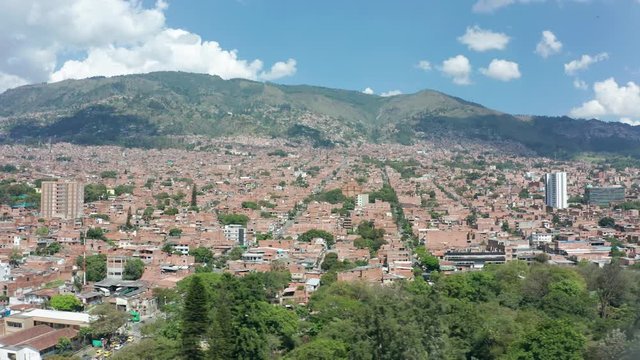 A beautiful aerial side pan shot of beautiful city next to green hill 