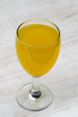 Energy tonic drink with turmeric, ginger, lemon and honey in glass , white wooden background, close up