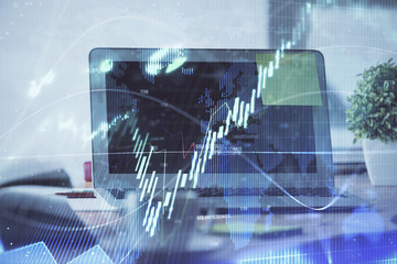 Stock market graph on background with desk and personal computer. Double exposure. Concept of financial analysis.