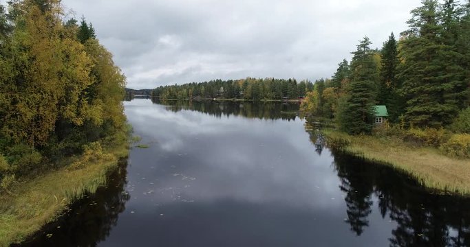 Aerial view of a beautiful lake in the forest with colorful trees during fall season. Taken in Kuru, Finland.
