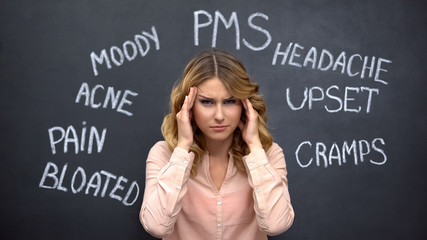 Woman suffering headache due to imaginary problems in pms, hormone imbalance - obrazy, fototapety, plakaty