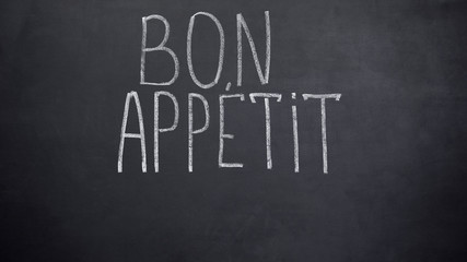 Obraz premium Bon Appetit phrase written on blackboard, high-end restaurant advertisement
