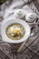 Sorrel soup with egg in white bowl.
