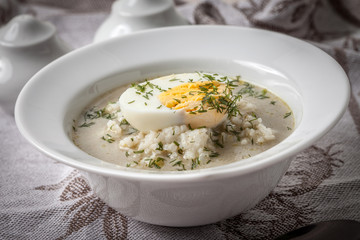 Sorrel soup with egg in white bowl.