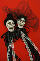 Bride and groom skull wedding dresses symbol of the day of the dead and hallowed, typical american party, with red background
