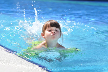 Little girl in swimming pool. Summer outdoor.