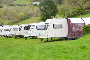 Touring caravans lined up on their pitches on a caravan site in rural Wales.