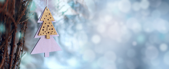 Christmas decoration in minimal style, wooden christmas tree shape. Wide banner, magickal bokeh...