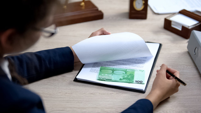 Female officer looking euro banknotes under visa application, embassy corruption