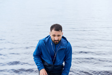 Outdoor portrait of sportsman in blue raincoat