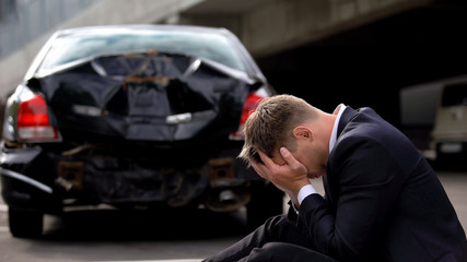 Fototapeta na wymiar Desperate driver on damaged auto background, smashed transport insurance, safety