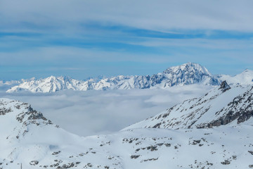 Beautiful and serene landscape of mountains covered with snow in Mölltaler Gletscher, Austria. Thick snow covers the slopes. Clear weather. There is a fog in the valley. Glacier skiing