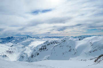 Fototapeta na wymiar Beautiful and serene landscape of mountains covered with snow in Mölltaler Gletscher, Austria. Thick snow covers the slopes. Clear weather. Perfectly groomed slopes. Massive ski resort. Glacier skiing