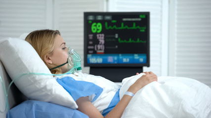 Crying woman in reanimation waking up after abortion, ecg monitor in room