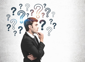 Thoughtful businessman, question marks sketch