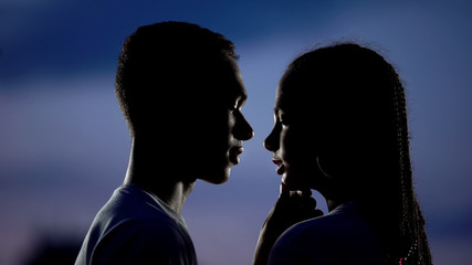 Lovely couple dreaming of romantic kiss in darkness, shy inexperienced teens