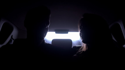 Young man and woman talking in automobile, driving to evening party, stars life