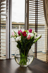 Bouquet of flowers in a vase on a coffee table in the interior of the room