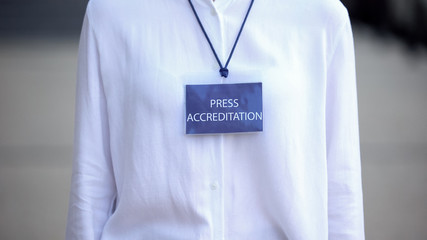 Close-up of female with press accreditation badge, journalist event pass, access