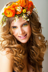 Naklejka premium Beauty young woman with flowers and make up close up, real spring beauty happy smiling