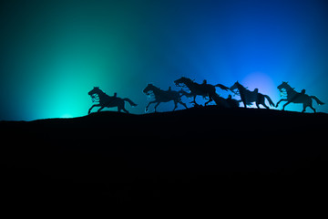 Fototapeta na wymiar horse silhouette on the top of a hill against dark toned foggy background. Creative composition.