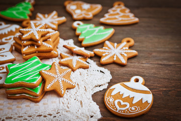 Obraz na płótnie Canvas festive Christmas gingerbread cookies in the shape of a star lie on a wooden dark brown background.