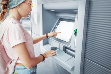 Asian woman withdraws money and pays the credit for study at the street European ATM self-service...